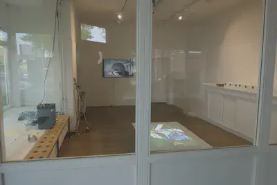 Blick in den auffordernden Raum. Hinten eine Darstellung von Boullées, vorne auf dem Tisch die Projektion eines Films von Dürkop/Kapp/Schielein. Rechts nummerierte Behältnisse auf einer Anrichte. Foto: Axel Dürkop