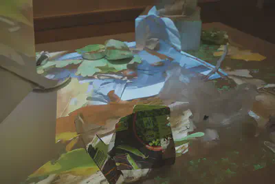 Alltagsgegenstände auf dem Tisch im Licht der Projektion. Im Laufe des Films erscheinen auf den Gegenständen Nummern, die mit den Behältnissen auf der Anrichte korrespondieren. Foto: Axel Dürkop